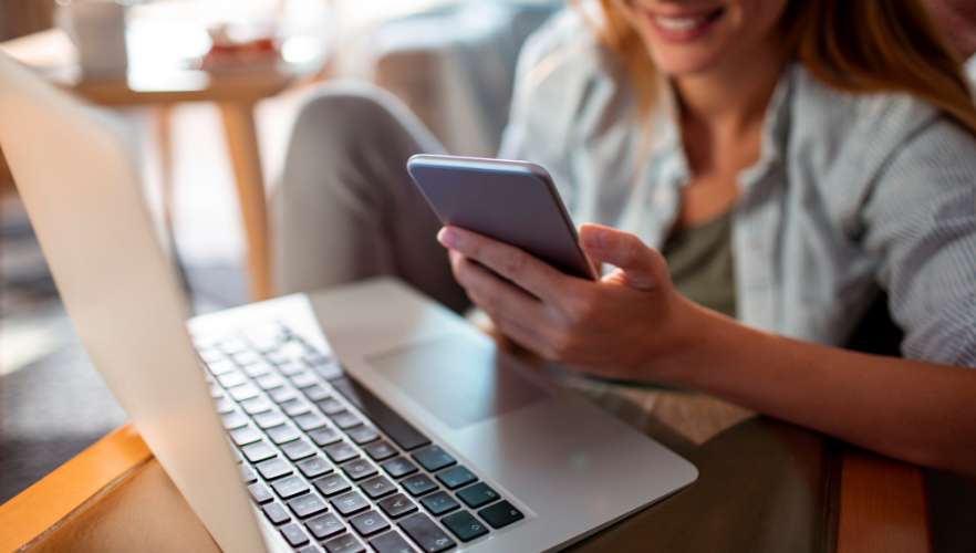 WOMAN WITH PHONE AND LAPTOP