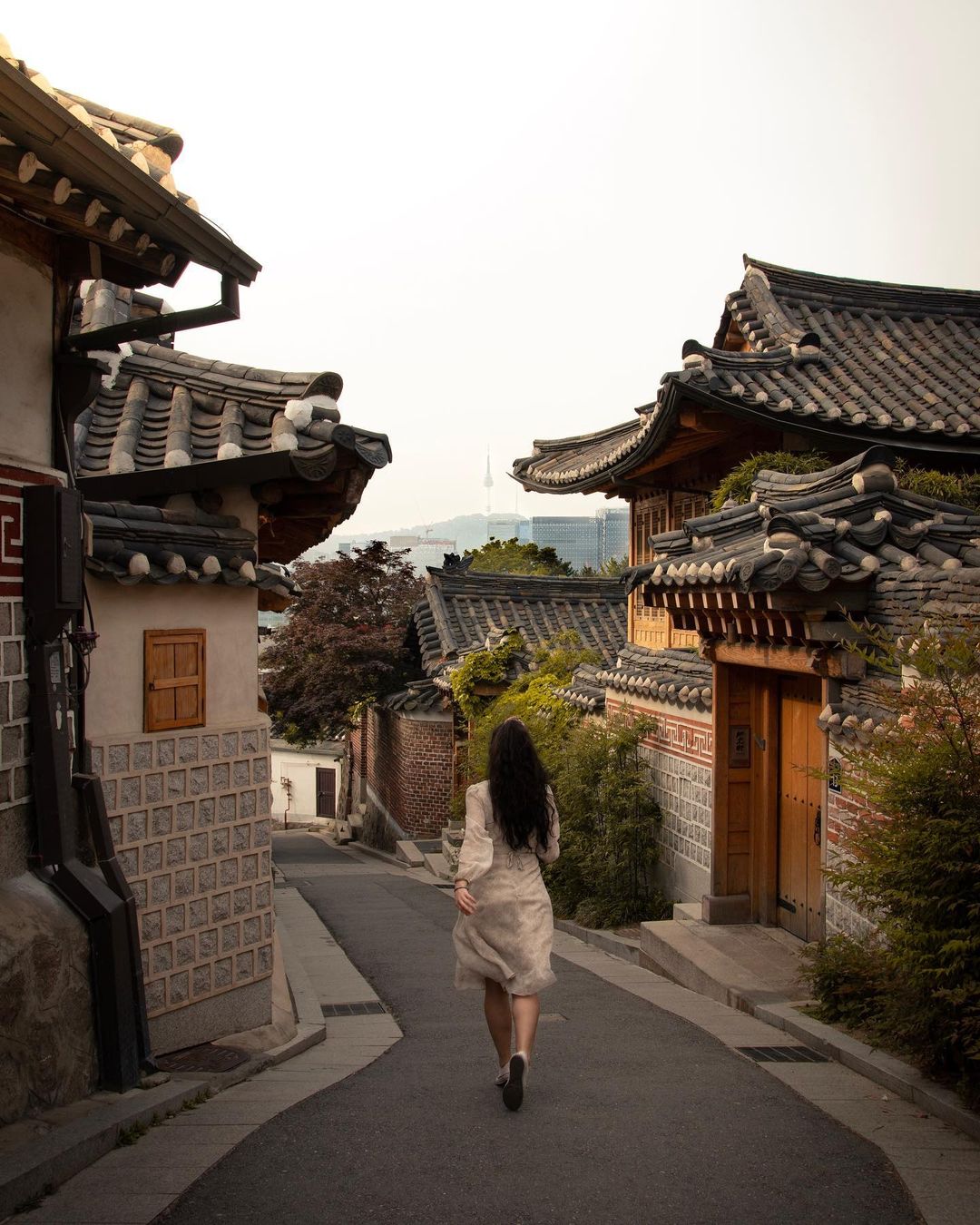A woman runs down a quiet street between houses - tefl internship in south korea